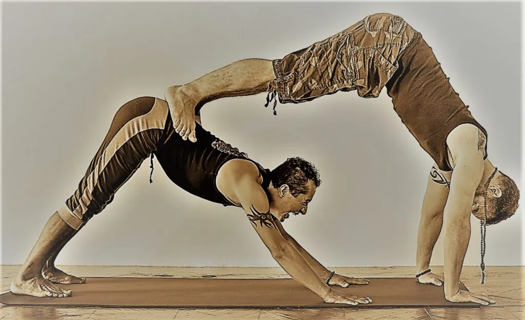 Jai and Victor Manuel in a couples Down Dog Pose