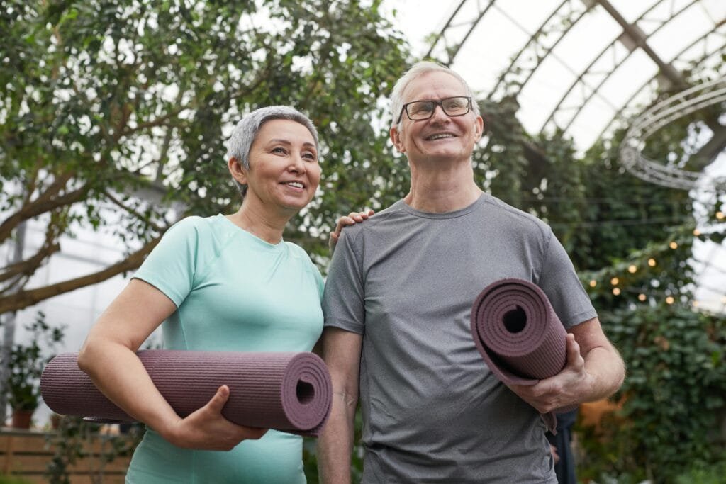 Private Yoga Couple Smiling While Holding Yoga Mats Private Yoga Couple Smiling While Holding Yoga Mats