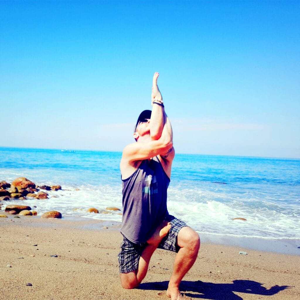 Yoga Teacher/Trainer Jai Salsbery E-RYT500 practicing Vatayanasana or Horse Face Pose on Los Muertos Beach in Puerto Vallarta.