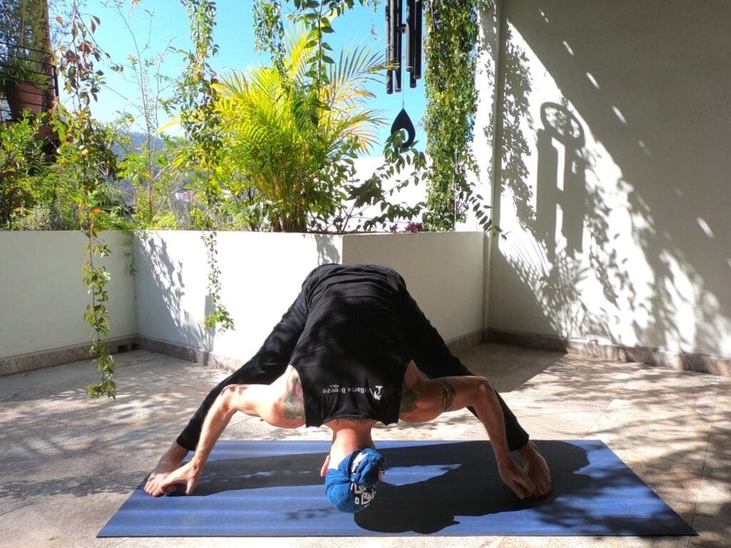 Deep Wide Legged Forward Bend Prasarita Padottanasana being performed by Jai Salsbery at the Vallarta Breeze Puerto Vallarta Yoga Studio.