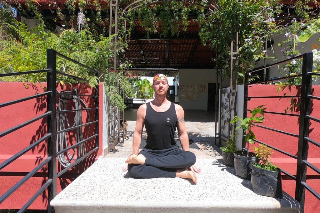 Yoga Teacher/Trainer, Jai Salsbery E-RYT500 performing Fire Log Pose (Agnistambhasana) on the steps to the Vallarta Breeze Yoga Puerto Vallarta Yoga Studio